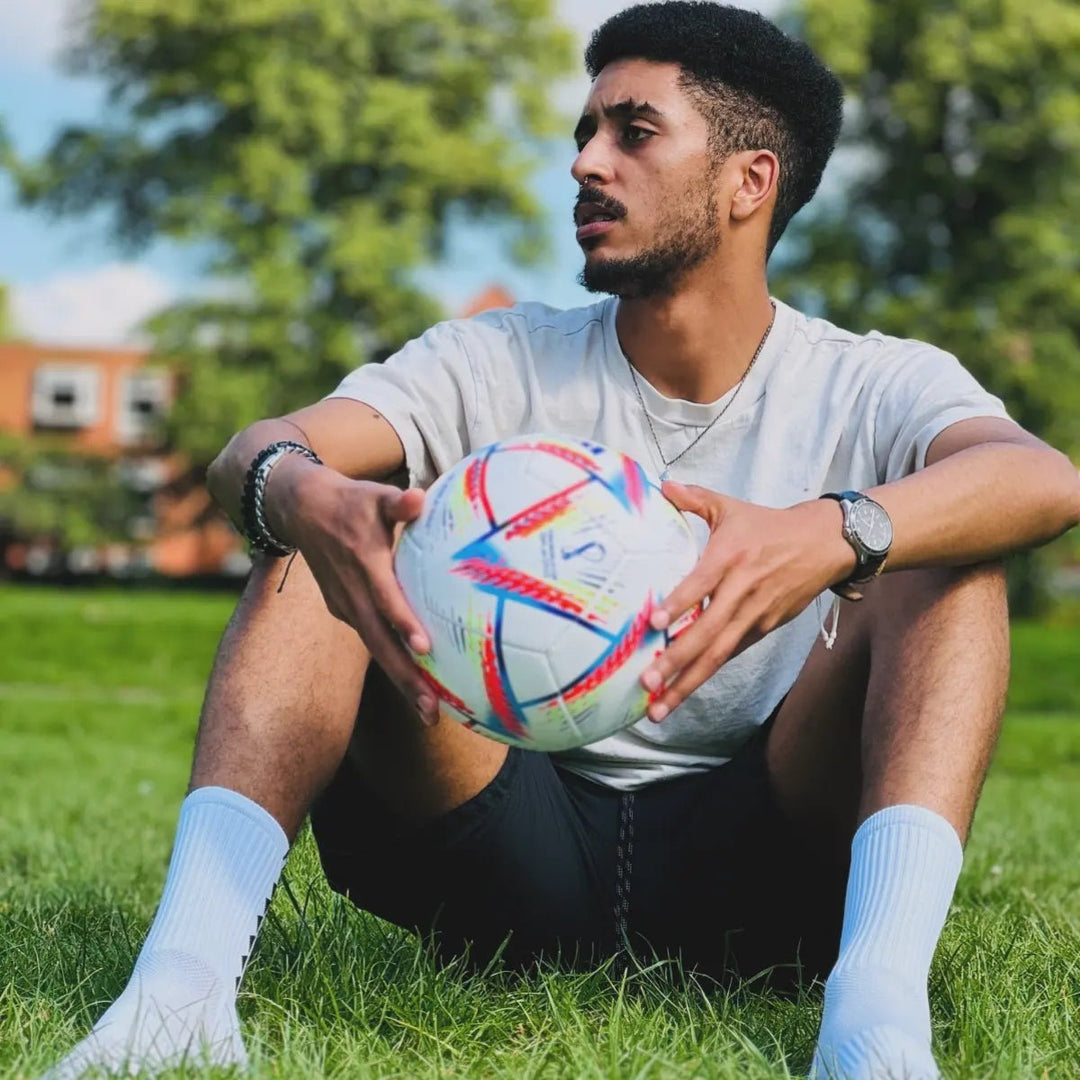 Man in Fitknitsocks white grip socks with a soccer ball, demonstrating grip socks effectiveness